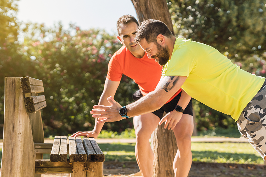 personal-trainer-next-to-a-man-doing-pushups-outdoor training